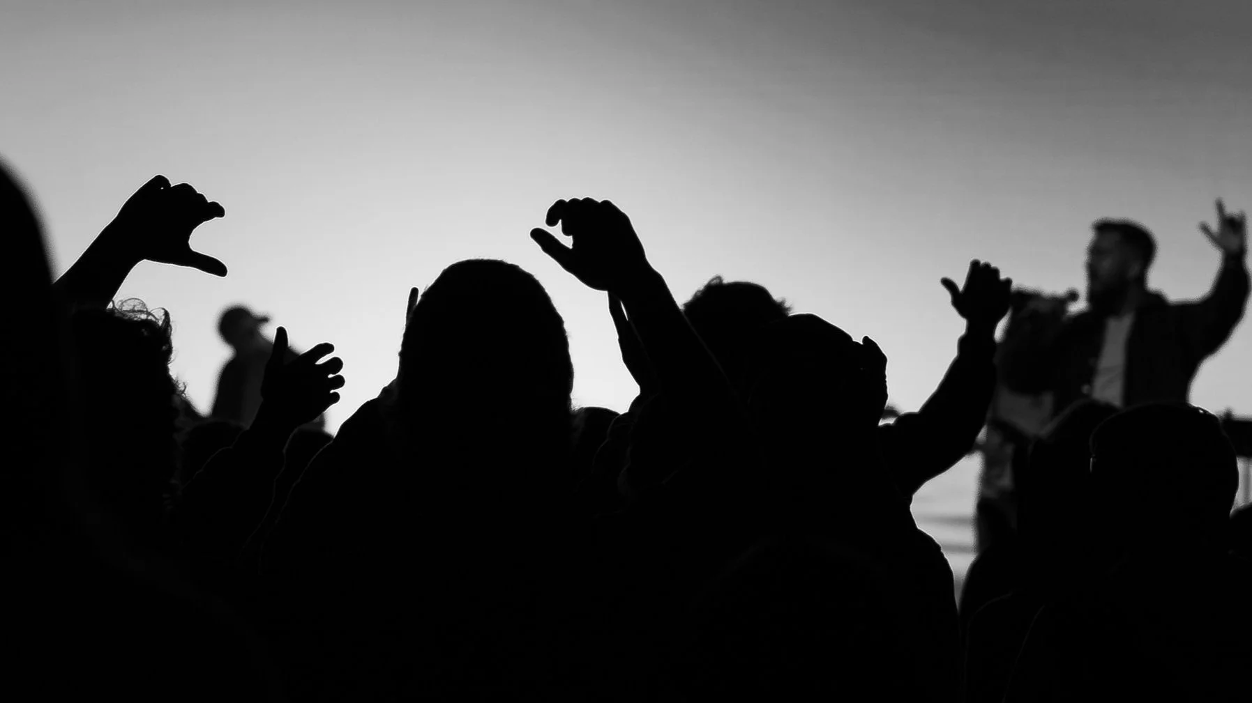 Silhouettes of hands raised in worship